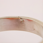 Close-up of a amber bangle bracelet on a light pink background