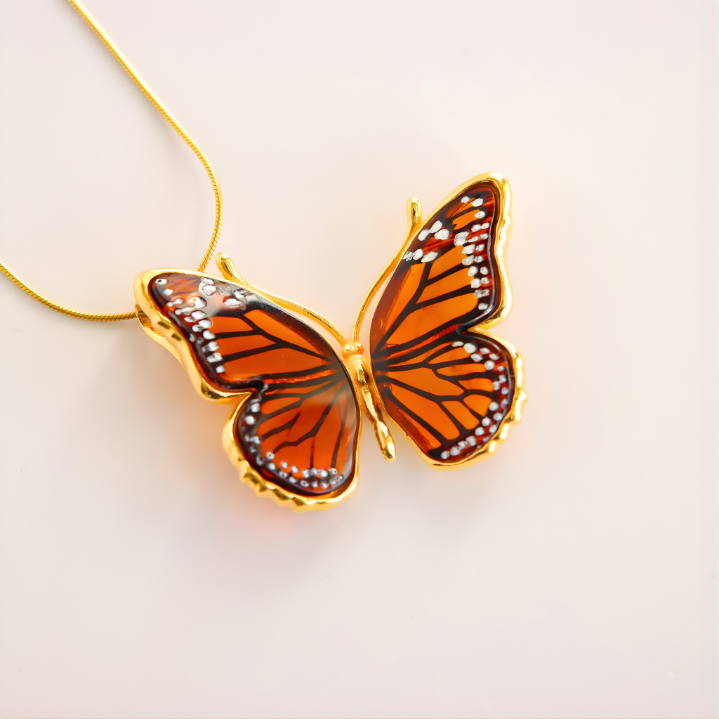 Butterfly necklace on a gold chain against a light background