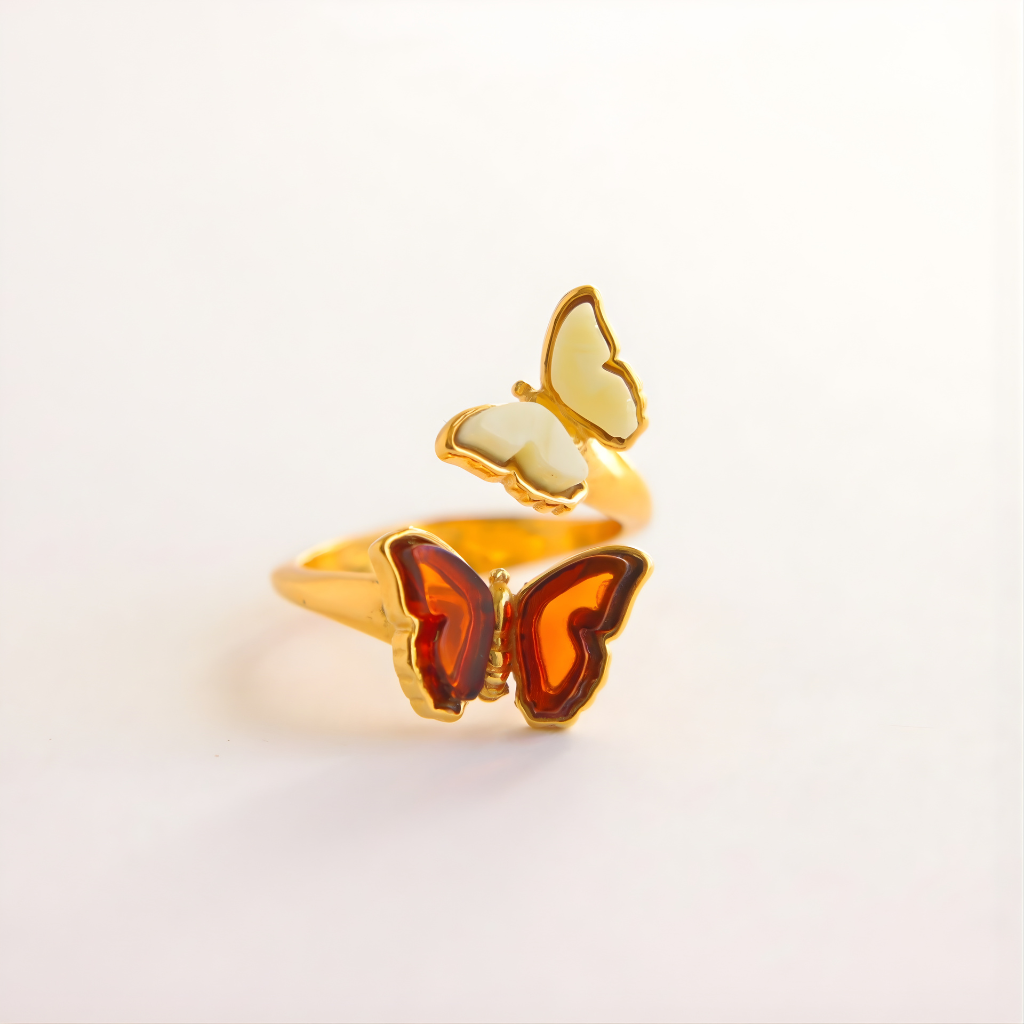 Butterfly ring with gold and amber colors on a light gray background