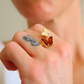 Close-up of a hand wearing butterfly ring with a blurred background