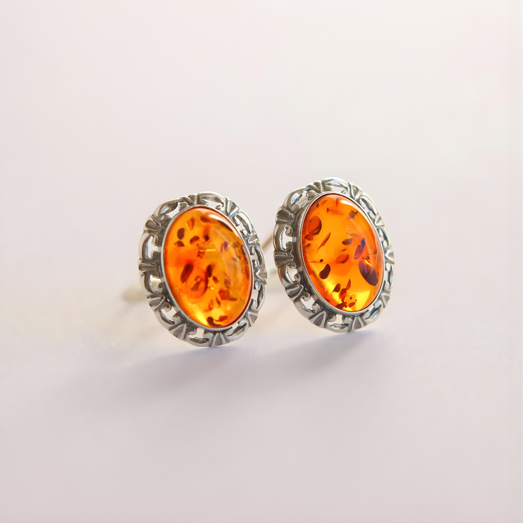 Pair of amber-stone clip on earrings with silver settings on a light gray background
