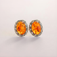 Pair of amber clip on earrings on a light gray background