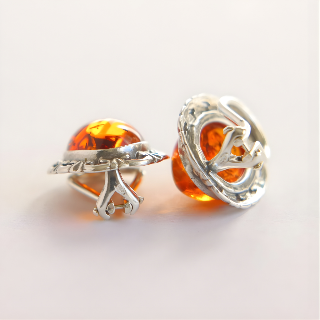 Silver clip on earrings with amber stones on a light background