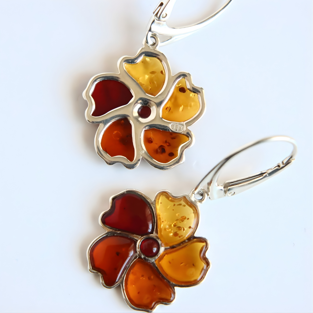 Flower-shaped amber earrings with amber-colored petals on a light blue background