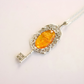 amber necklace with Silver key-shaped pendant with an orange amber stone on a white background