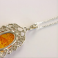 amber necklace with  Silver pendant with amber center on a light background