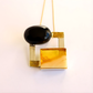 amber Necklace with black and gold pendant on a white background