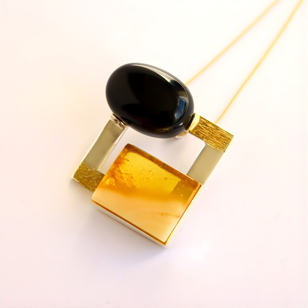 Amber Necklace with a black and gold pendant on a white background