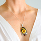 Amber Necklace with a sunflower pendant worn by a person in a white top