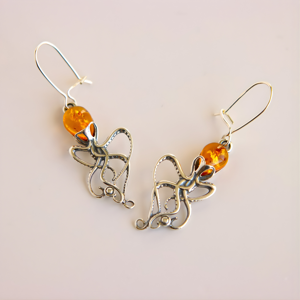 Pair of  Baltic amber octopus dangle earrings orange beads on a light background