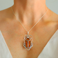 Silver necklace with a scarab pendant on a mannequin