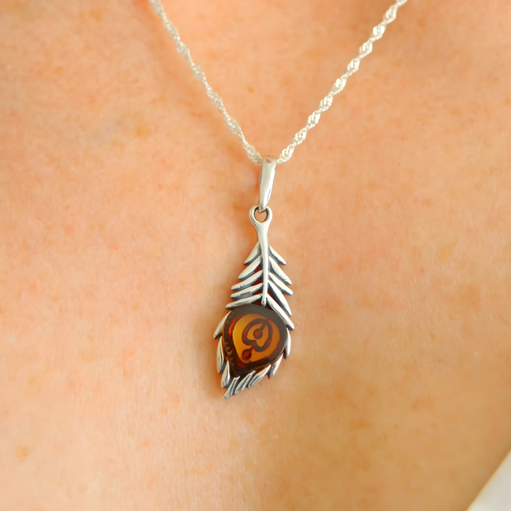 silver feather necklace close up on beige background
