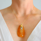 statement Necklace with an orange pendant on a plain background
