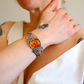 Close-up of a wrist wearing a sterling silver bracelet with an amber stone.