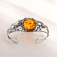 sterling Silver bracelet with a round amber stone on a light background