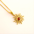 Gold amber sun necklace with a red gemstone on a light pink background