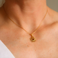 Gold amber sun necklace on a person's neck