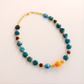 Beaded Necklace with blue, red, and orange beads on a light background