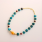 beaded Necklace with blue, red, and gold beads on a light background