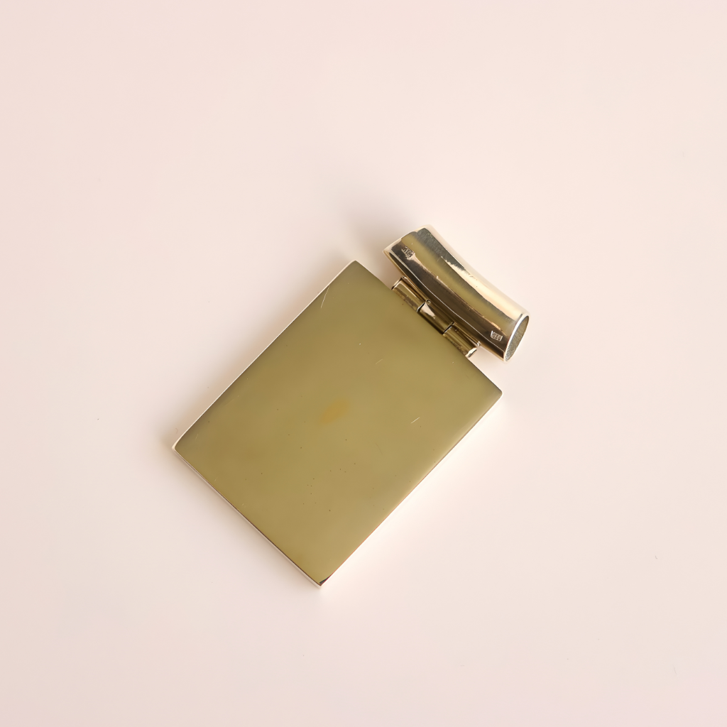 silver backside of turquoise pendant necklace on a beige background