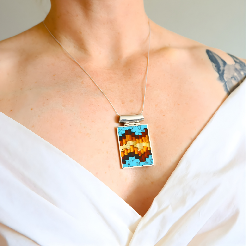 Turquoise Necklace with a colorful pendant worn by a person in a white top.