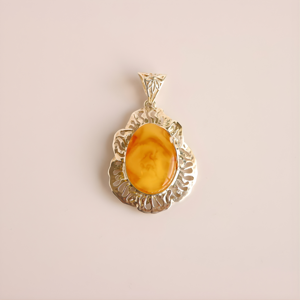 butterscotch amber pendant with a yellow stone on a beige background