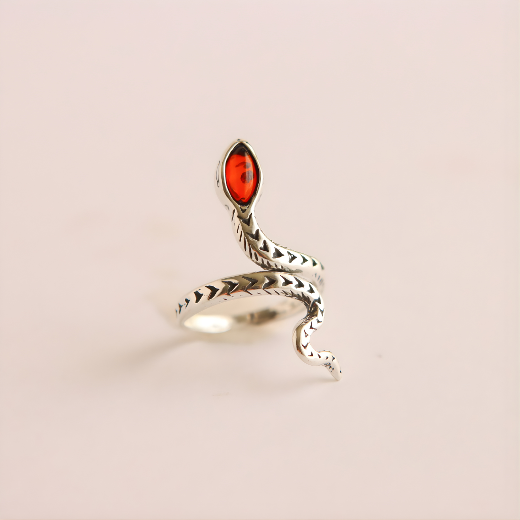 Silver snake ring with a red stone on a beige background