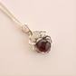 Spider charm necklace-with a red gemstone on a beige background
