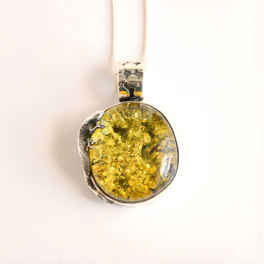 green amber Pendant with silver setting on a white background