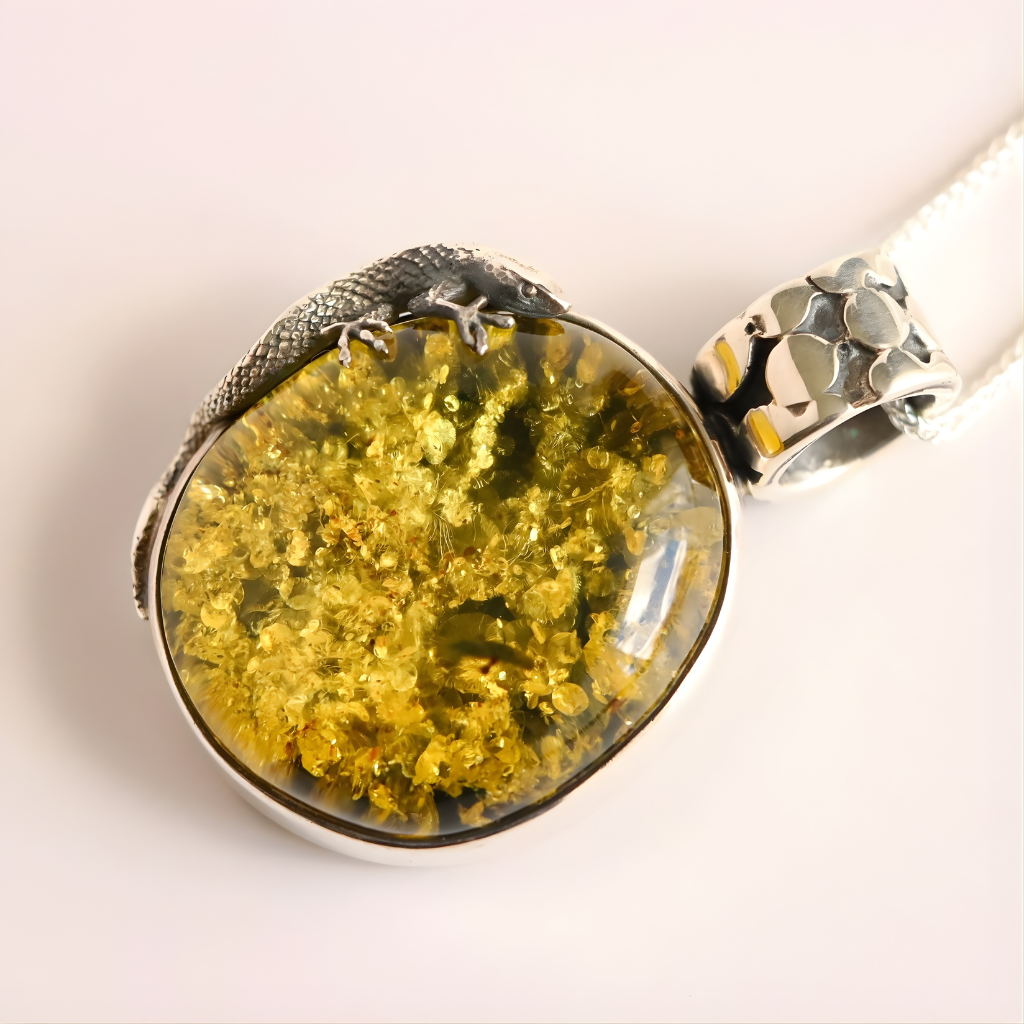 Silver and  green amber pendant on a white background