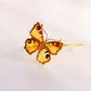 Gold butterfly amber bracelet on a light gray background