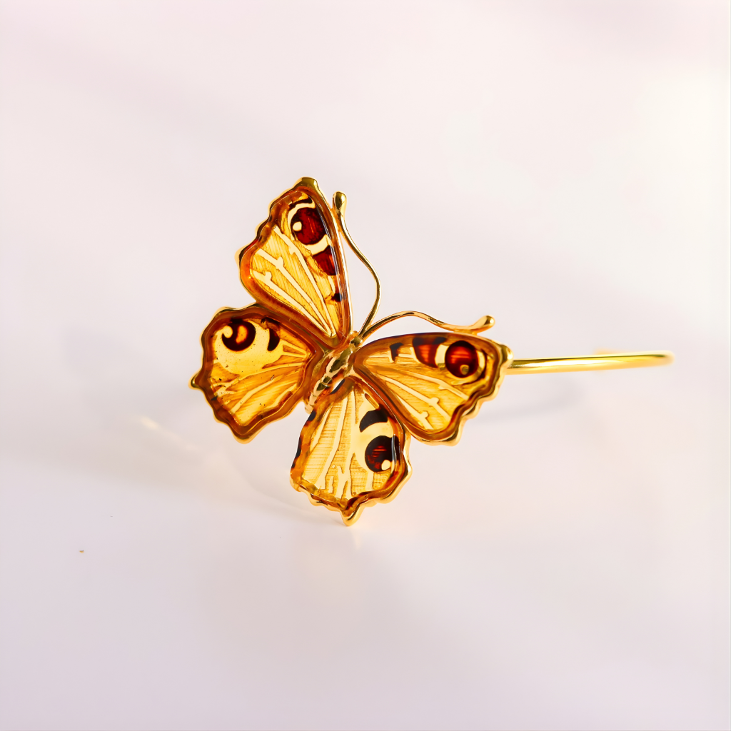 Gold butterfly amber bracelet on a light gray background