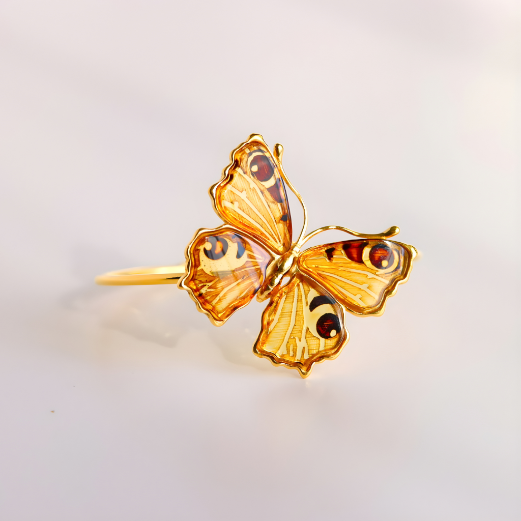 Gold butterfly amber bracelet  with brown accents on a light gray background