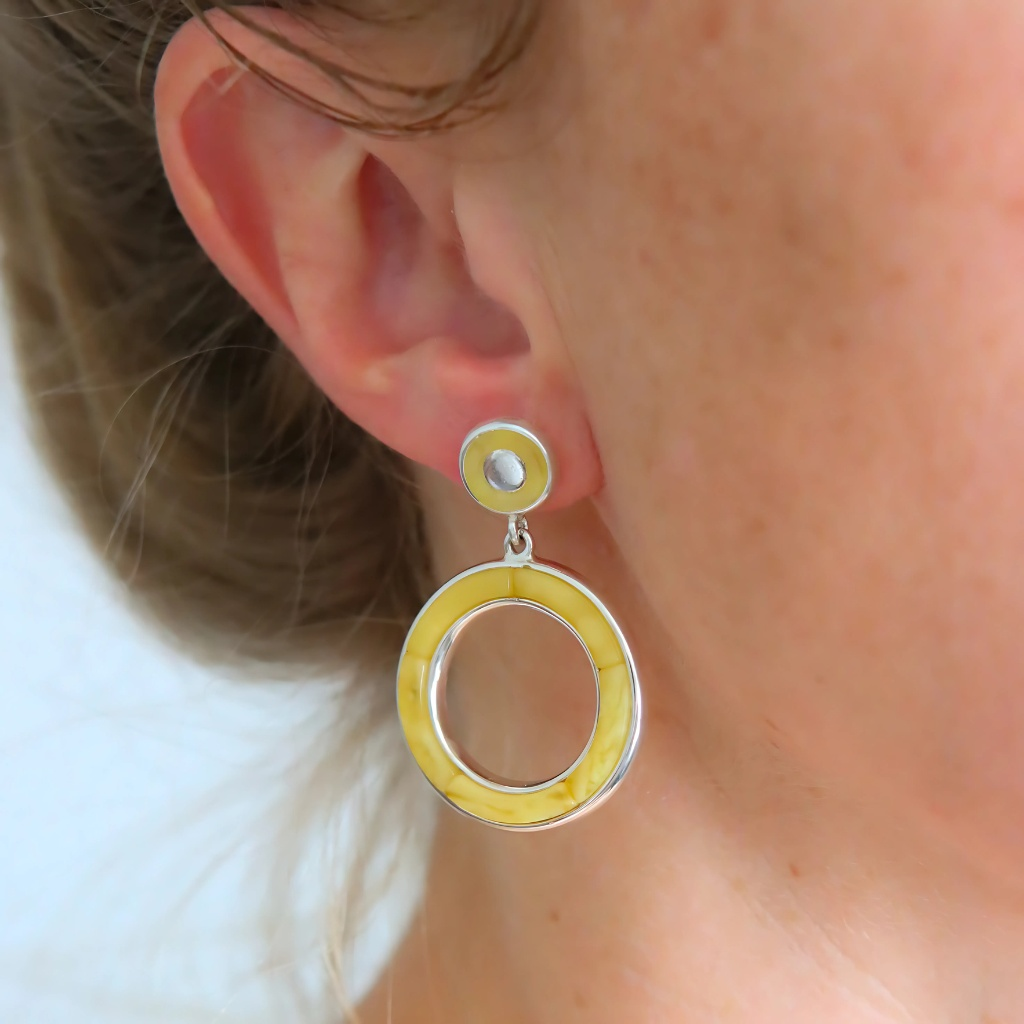 Close-up of a person wearing a yellow and silver earring.