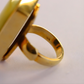Gold amber statement ring on a light gray background