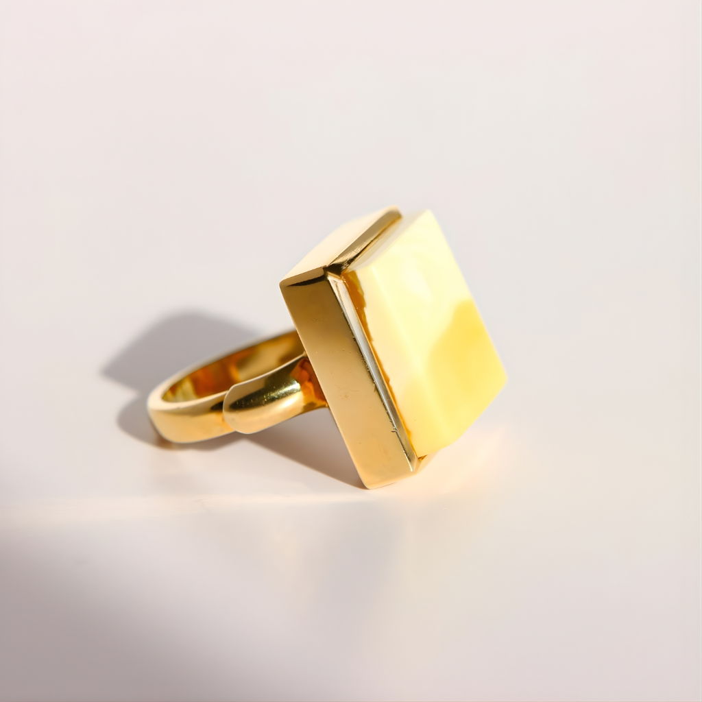 Gold amber ring with a geometric design on a light gray background
