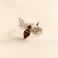 amber bee ring with silver wings on light beige background