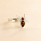 bee ring with silver filigree wings on light beige background