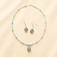silver turquoise necklace and earrings set on light beige background