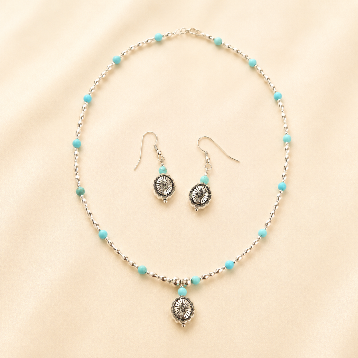 silver turquoise necklace and earrings set on light beige background
