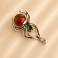 amber spider pendant with brown gemstone on beige background