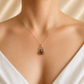 model wearing a white top wearing orange amber spider pendant necklace on light cream background