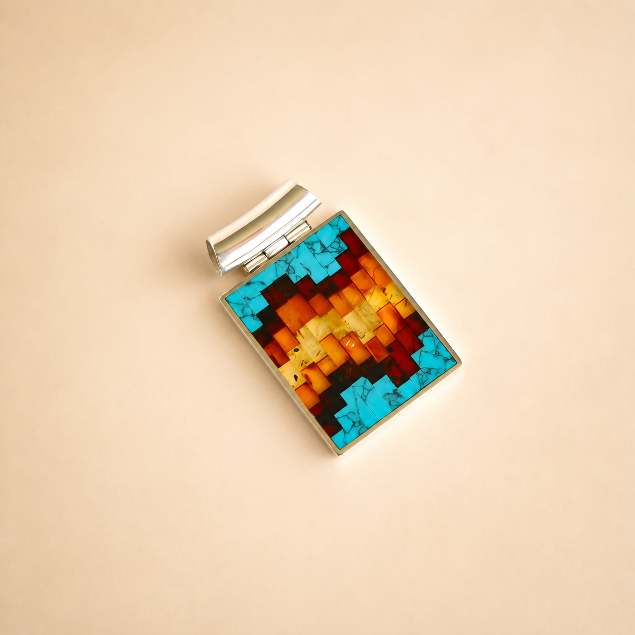 Colorful rectangular turquoise necklace pendant with a silver setting on a beige background