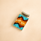 Rectangular pendant turquoise necklace with woven pattern on a beige background