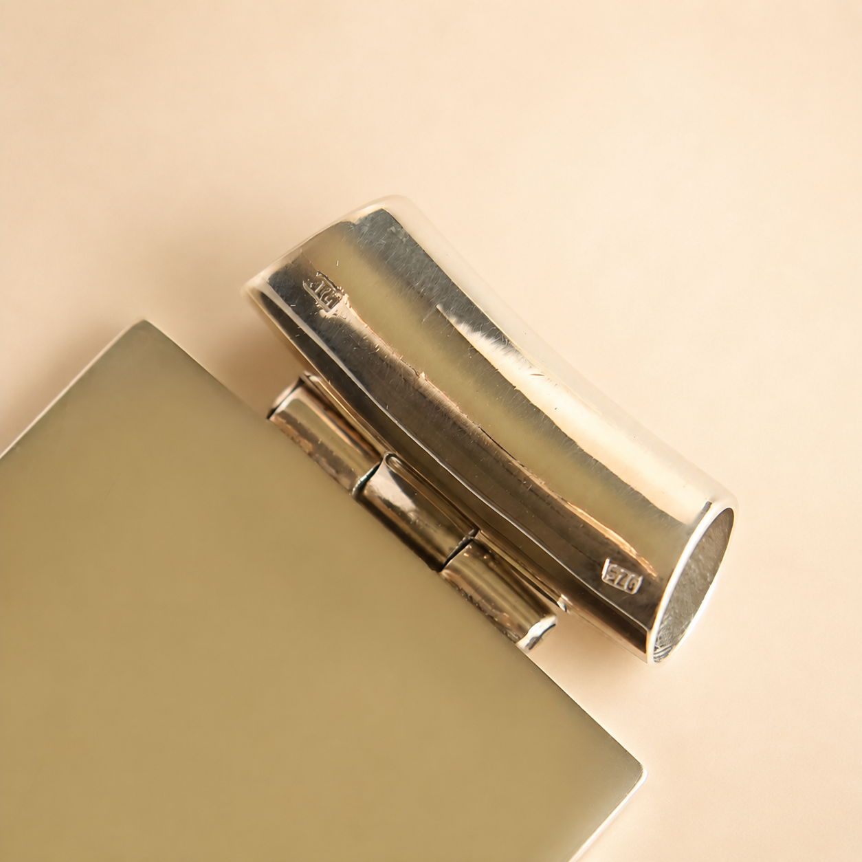 Close-up of a metallic hinge with 925 stamp on a beige background for turquoise necklace
