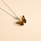 Butterfly necklace on a beige background