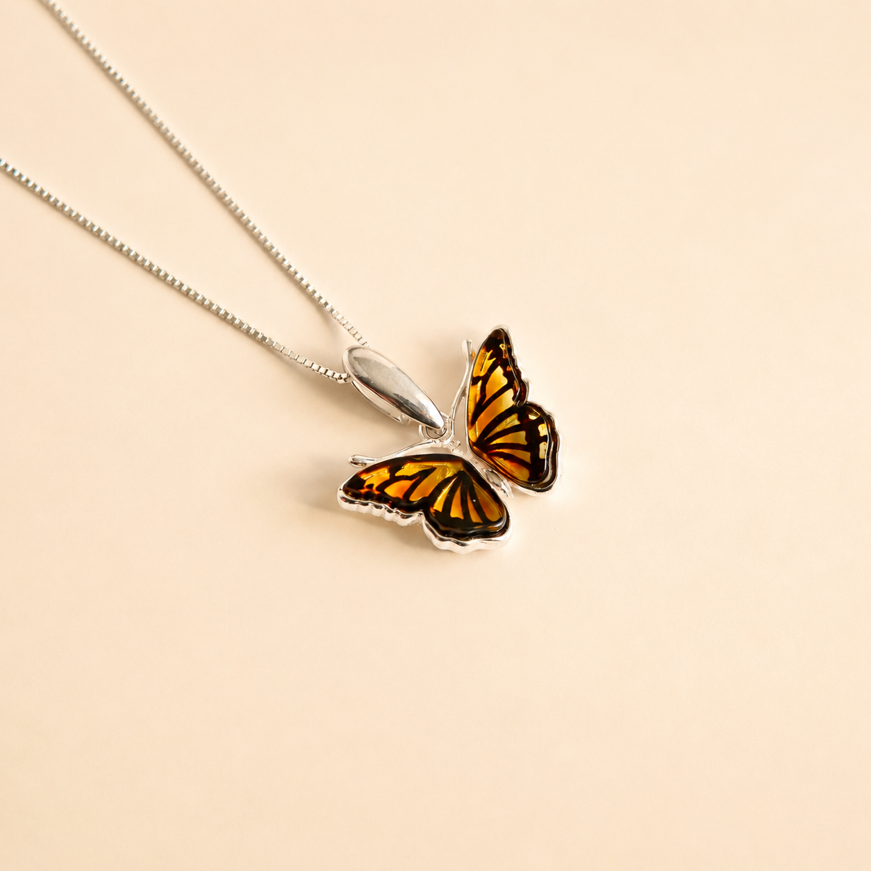 Butterfly necklace on a beige background