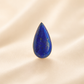 Teardrop-shaped lapis lazuli ring on a beige background