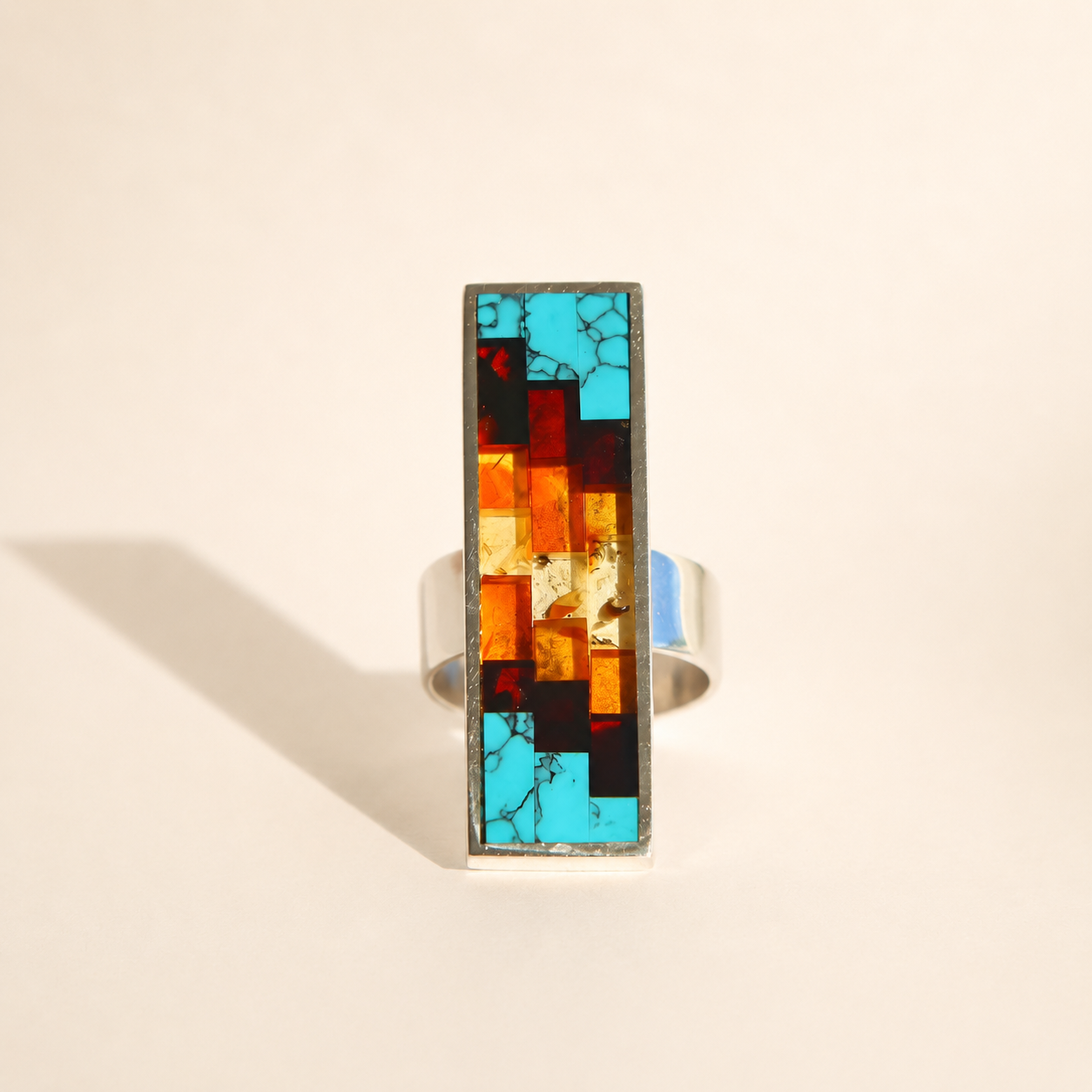 Multicolored mosaic amber ring on a beige background