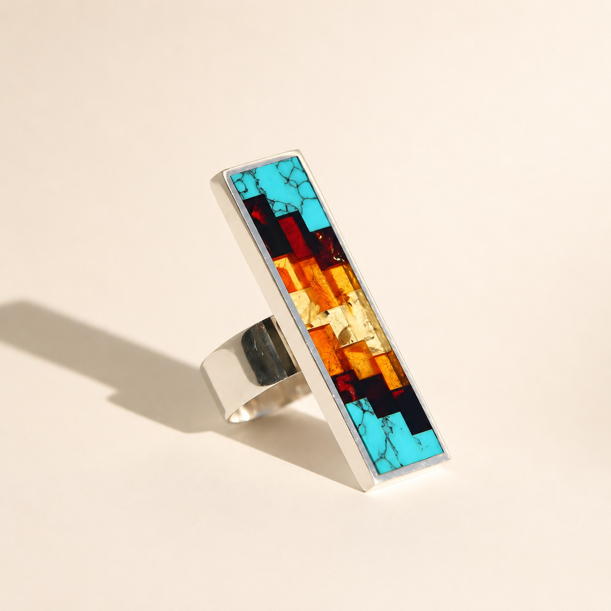 Amber Ring with colorful gemstone inlay on a beige background
